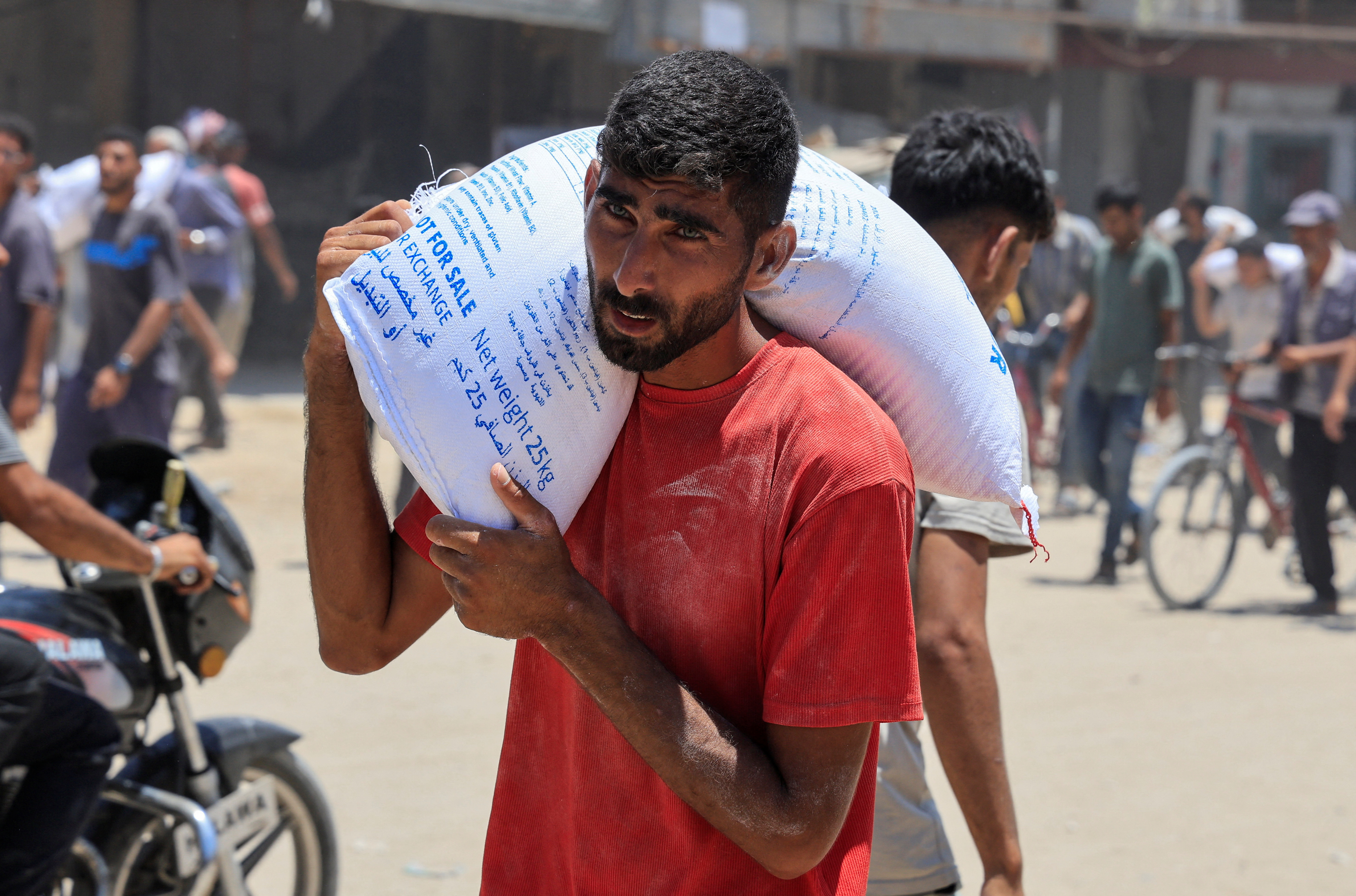 فلسطيني يحمل حصته من المساعدات في خان يونس جنوب غزة-26 جوان/جوان 